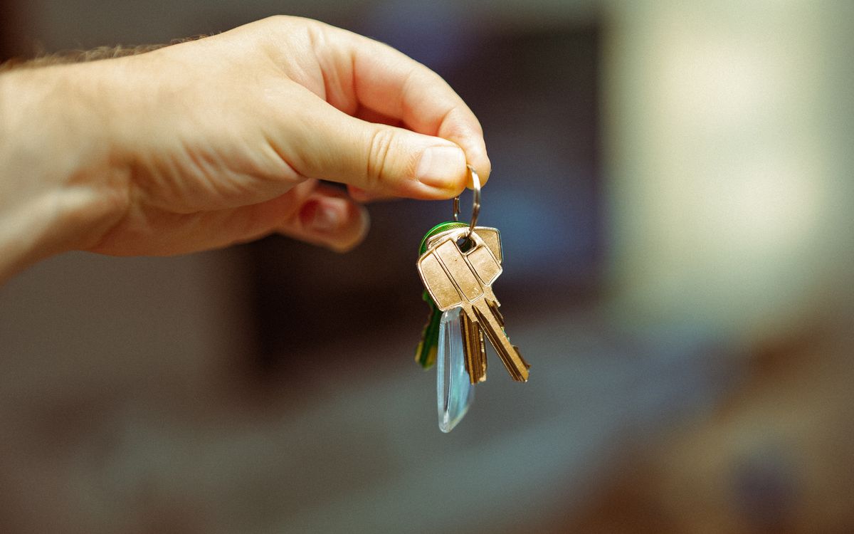 A hand holding house keys